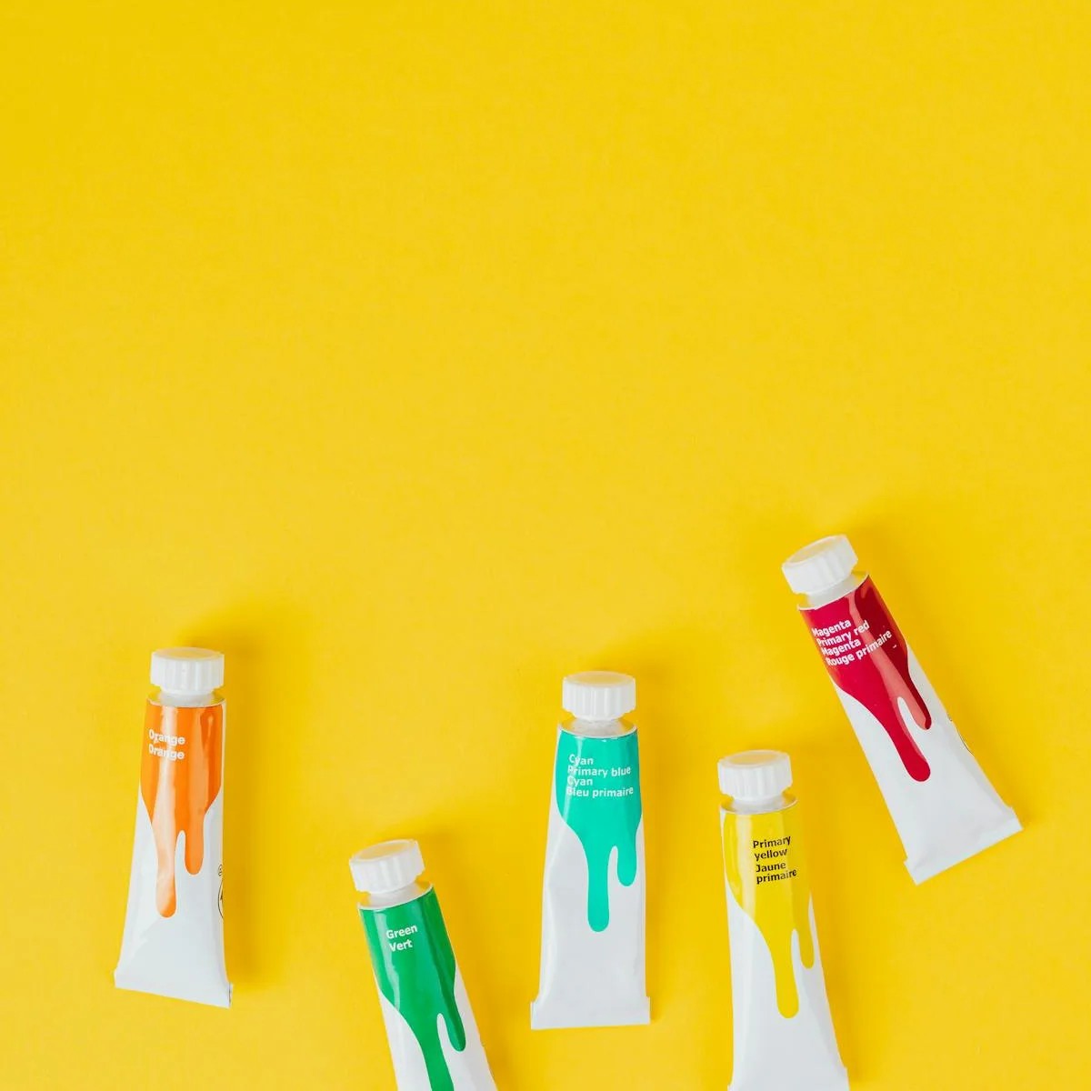 kirkkaan keltainen tausta jossa neljä eri tyyppistä maalituubia.