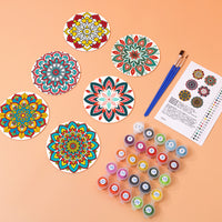 Thumbnail for Valmiiksi maalatut mandala-lasinaluset, maalit, siveltimet ja värikortti pöydällä