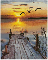 Thumbnail for Timanttimaalaus mallikuva – puinen laituri johtaa tyynelle järvelle, kultainen auringonlasku ja lentävät linnut luovat rauhallisen tunnelman.