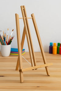 Thumbnail for Kevyt puinen maalausteline askartelupöydällä. Teline on noin 50 cm korkea ja 27 cm leveä, täydellinen pöytäkäyttöön maalauksiin ja numeromaalauksiin. Taustalla näkyy siveltimiä ja värikkäitä maalaustarvikkeita.