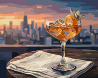 Thumbnail for Cocktail-lasi auringonlaskussa numeromaalaus. Etualalla juomalasi, taustalla kaupunkisiluetti.